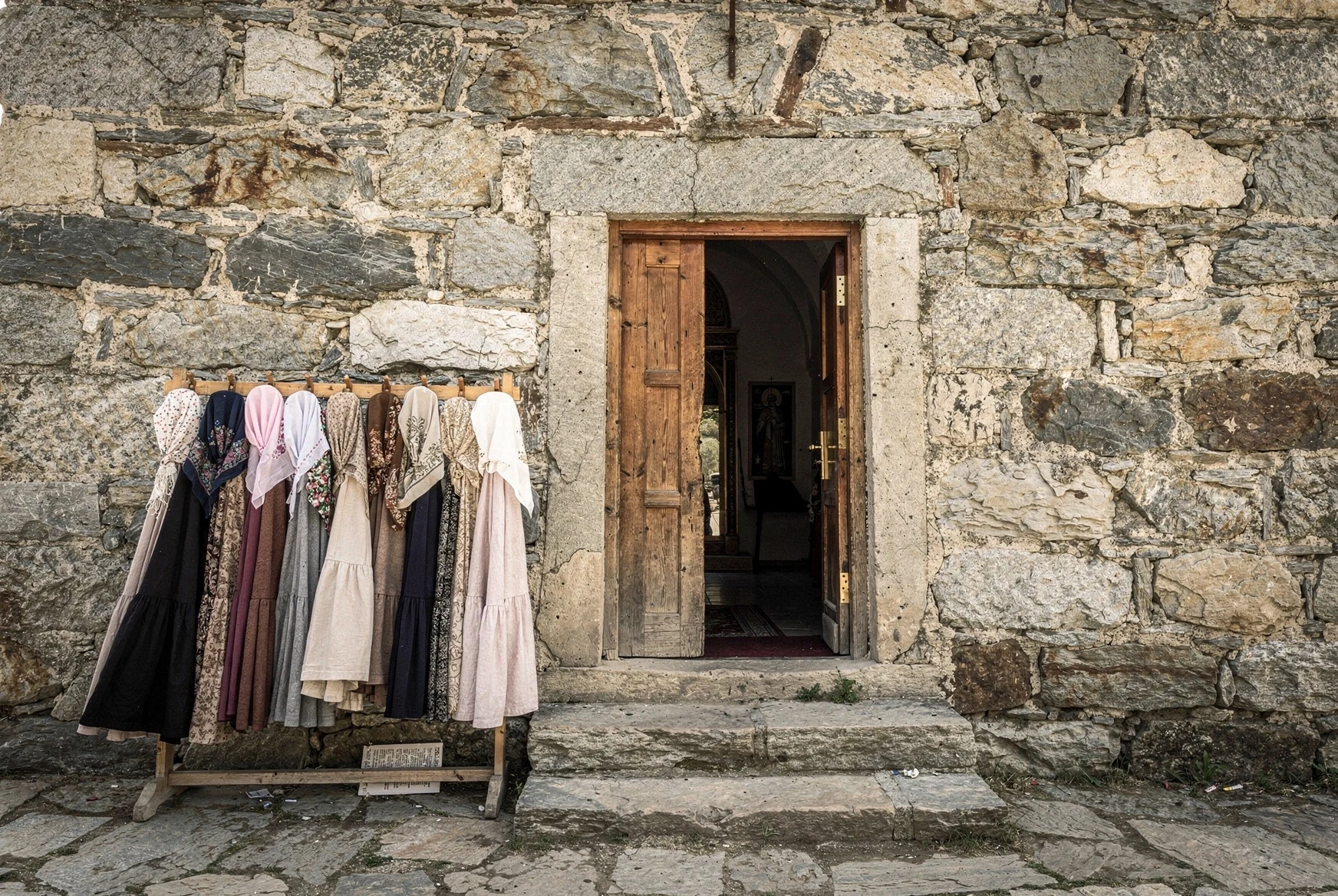 Headscarves and wrap skirts hanging beside the entrance of a Georgian Orthodox church