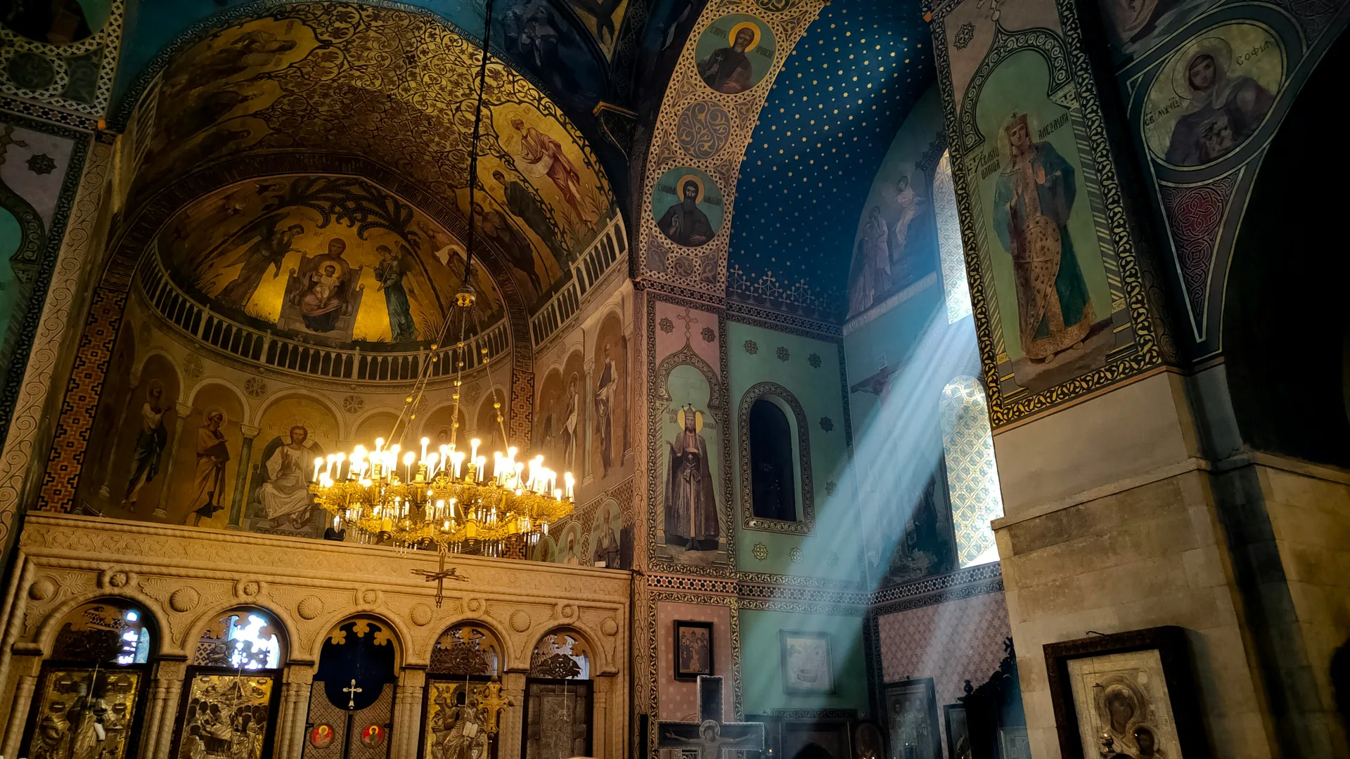 Interior of an Orthodox church with frescoes and golden chandelier