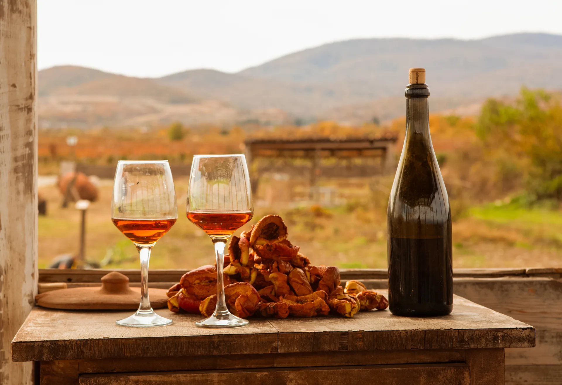 Wine bottle and glasses on an old wooden table in a rustic Georgian setting