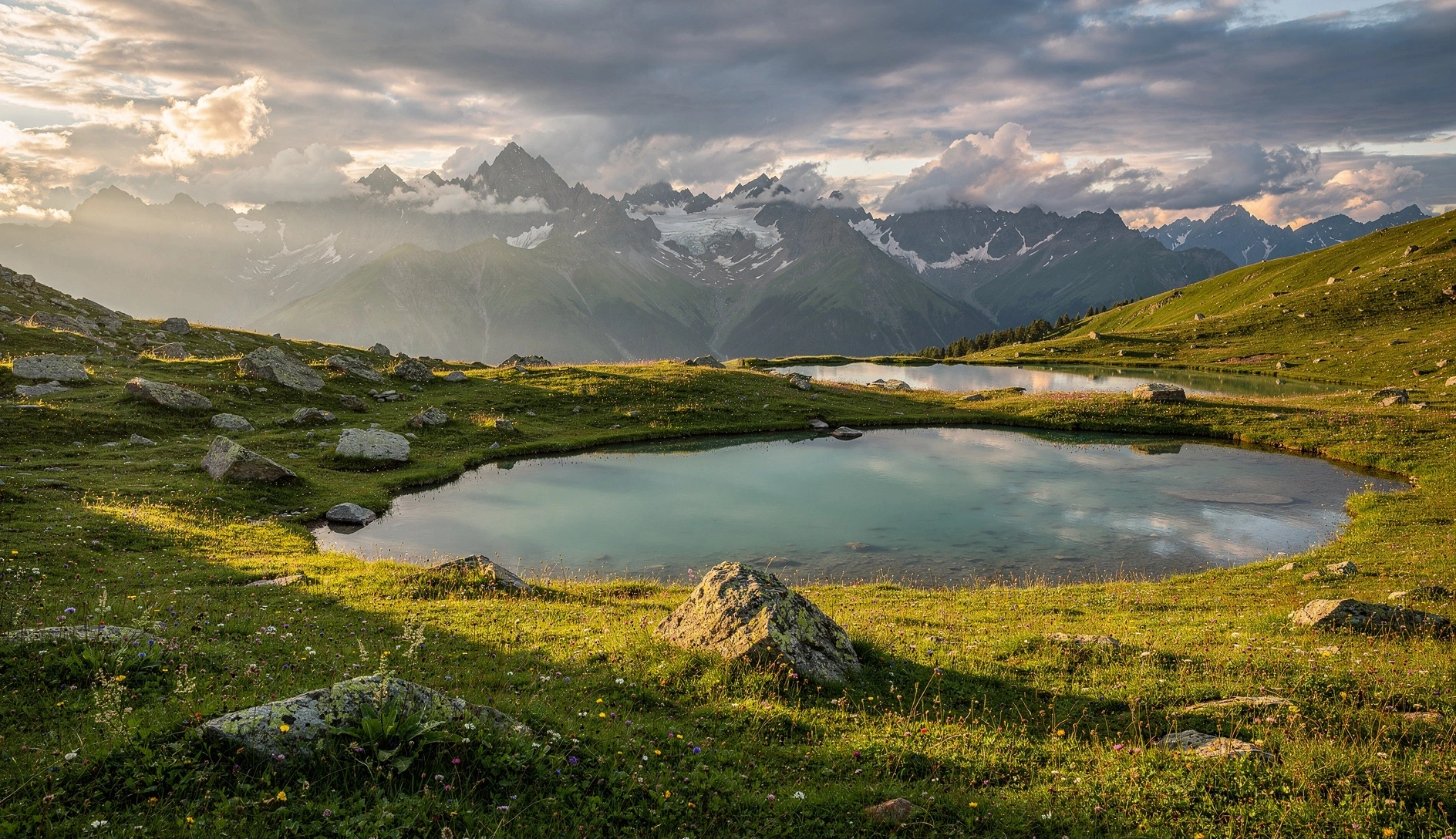 Alpine lakes reflecting jagged Caucasus peaks in green meadows above Mestia, Svaneti, Georgia