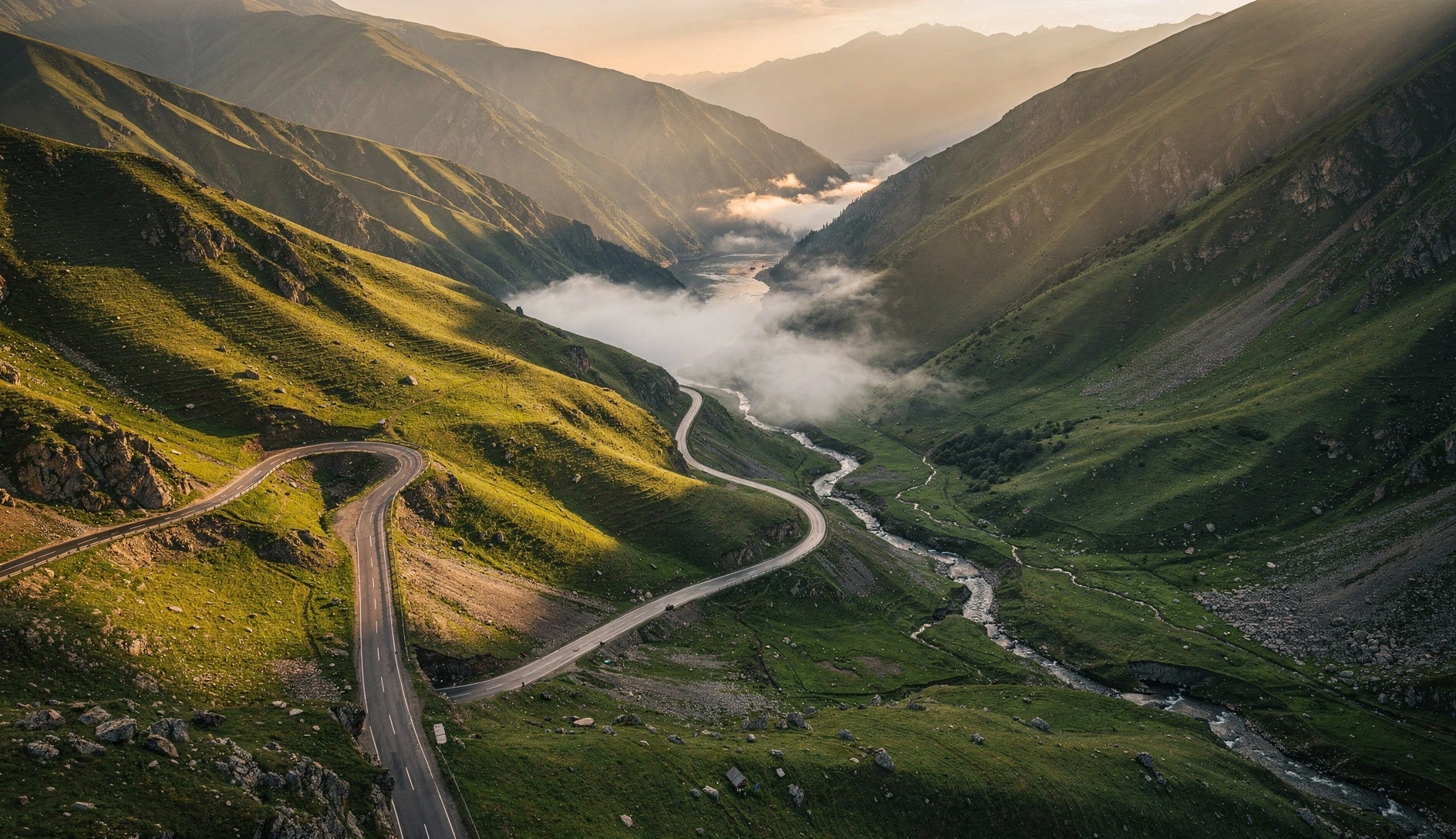 Winding mountain road cutting through lush green Caucasus valleys in Georgia at golden hour