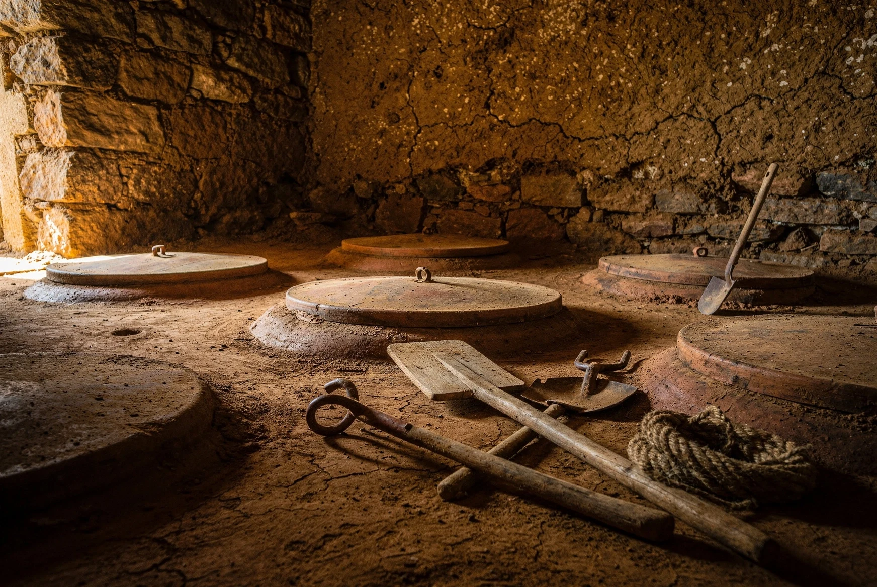 Qvevri lids and traditional tools inside a Georgian marani