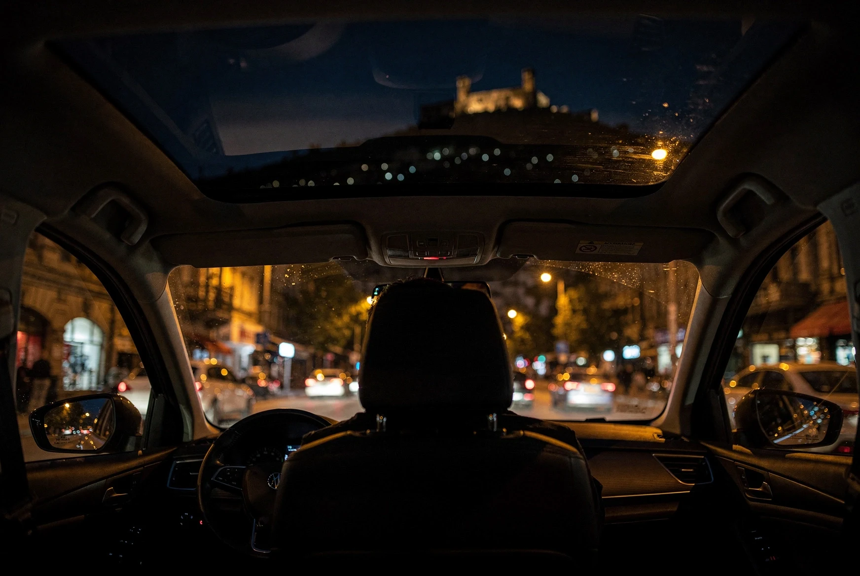 Night-time view from inside a car driving through central Tbilisi