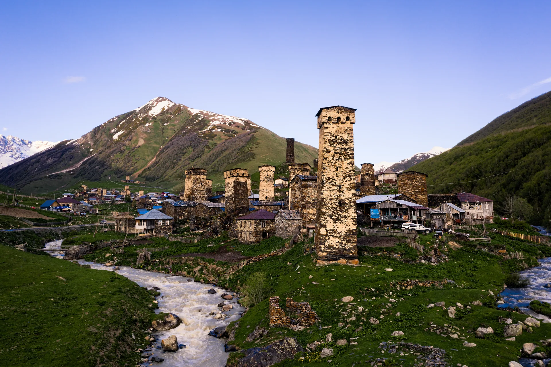 An ancient medieval Svan tower in the historic village of Ushguli with stone walls and mountain backdrop